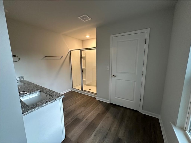 bathroom with hardwood / wood-style flooring, walk in shower, and vanity