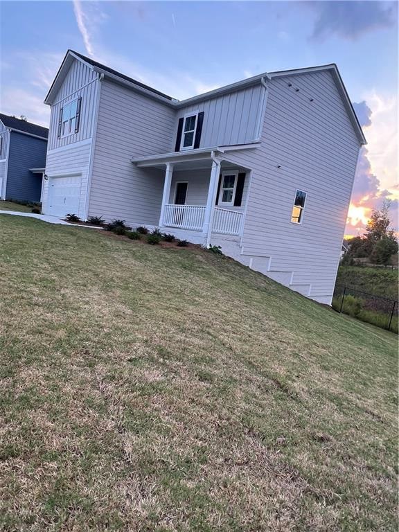 exterior space featuring a yard, a porch, and a garage