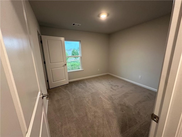 empty room featuring dark colored carpet