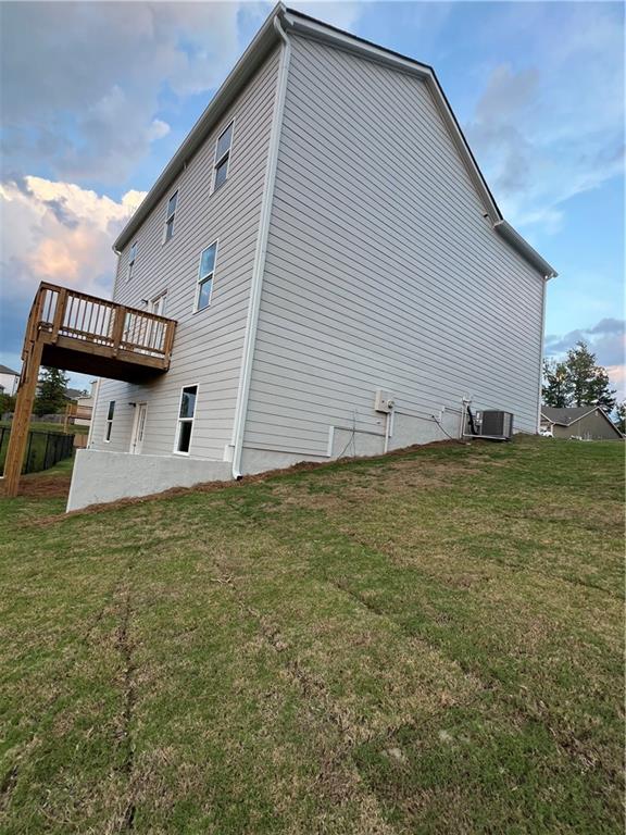 exterior space featuring a lawn and central AC