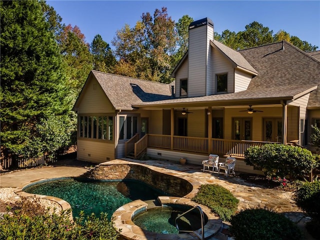 back of property featuring ceiling fan and an in ground hot tub