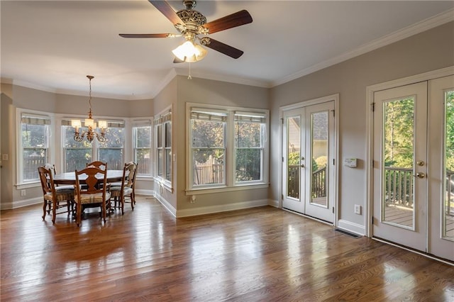 dining space with ceiling fan with notable chandelier, crown molding, and french doors