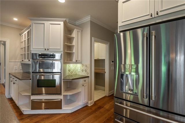 kitchen featuring decorative backsplash, appliances with stainless steel finishes, white cabinetry, and ornamental molding