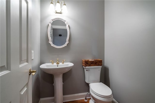 bathroom featuring sink, a chandelier, and toilet