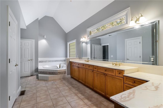 bathroom with lofted ceiling, tile patterned flooring, vanity, and tiled tub