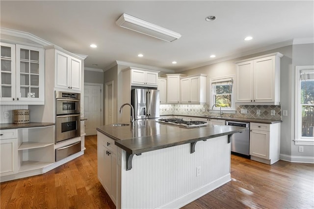 kitchen with sink, white cabinetry, appliances with stainless steel finishes, a kitchen breakfast bar, and an island with sink