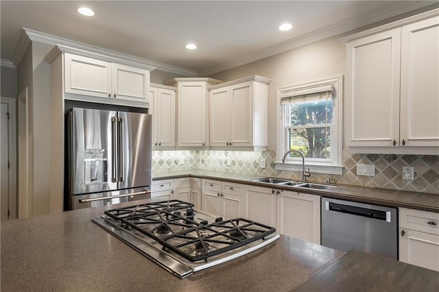 kitchen with white cabinetry, ornamental molding, appliances with stainless steel finishes, and sink