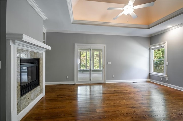 unfurnished living room featuring crown molding, a raised ceiling, and a fireplace