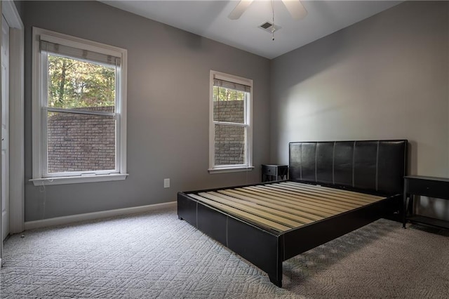 carpeted bedroom with ceiling fan and multiple windows