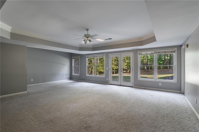 carpeted empty room featuring ceiling fan, a tray ceiling, and ornamental molding