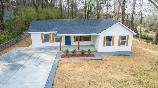 modern inspired farmhouse featuring driveway, a porch, fence, board and batten siding, and a shingled roof