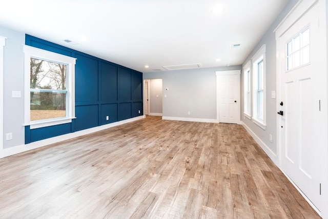 interior space with baseboards and light wood finished floors