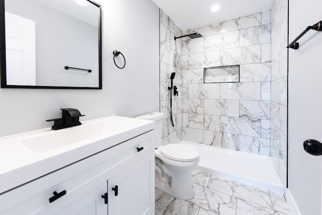 full bath with tiled shower, toilet, marble finish floor, and vanity