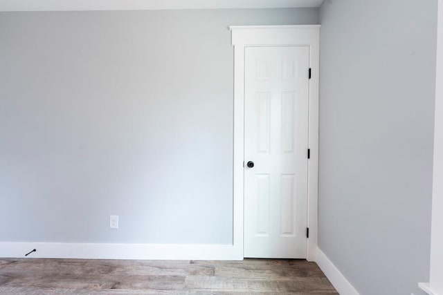 unfurnished room featuring baseboards and wood finished floors