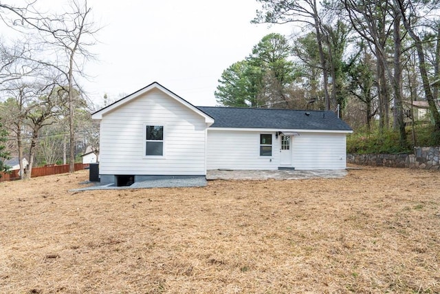 rear view of house featuring a patio, central AC unit, a shingled roof, and fence