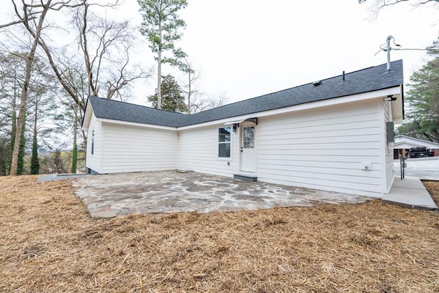 back of house with a patio area and a shingled roof