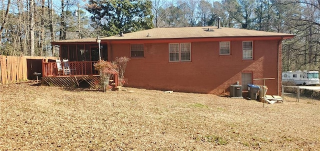 back of house featuring central air condition unit, a wooden deck, and a sunroom