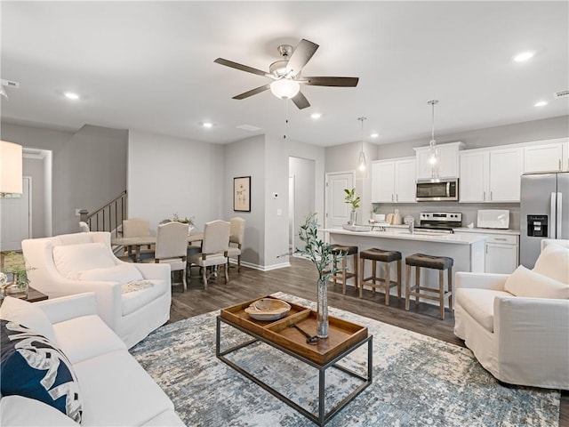 living room featuring ceiling fan and dark wood-type flooring