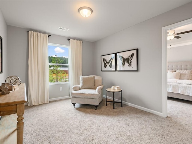 living area with carpet floors and ceiling fan