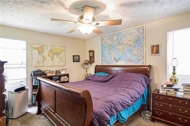 bedroom featuring multiple windows, ceiling fan, light colored carpet, and a textured ceiling