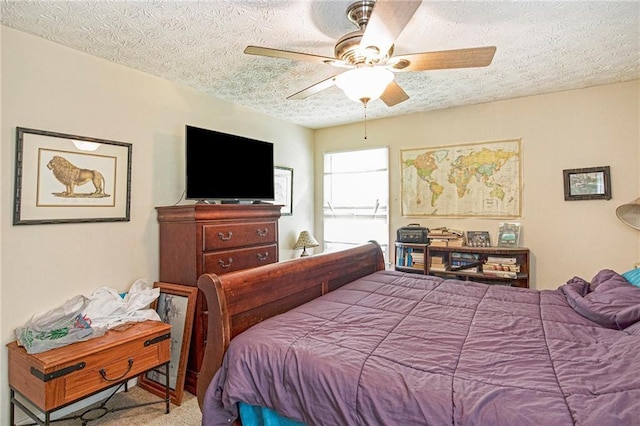 carpeted bedroom with ceiling fan and a textured ceiling