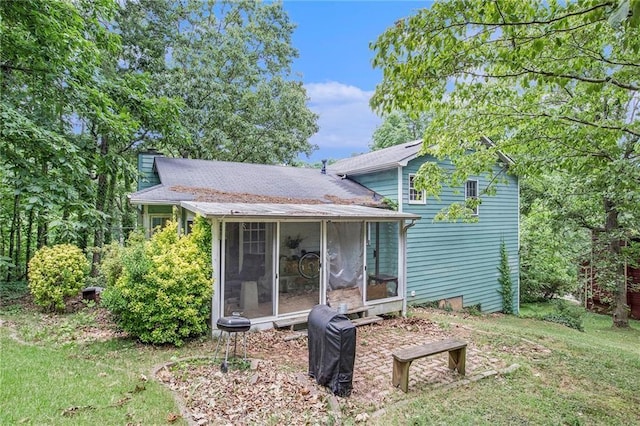 rear view of property with a yard and a sunroom