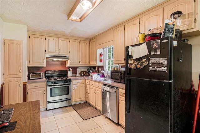 kitchen featuring sink, light tile patterned floors, stainless steel appliances, light brown cabinets, and a textured ceiling