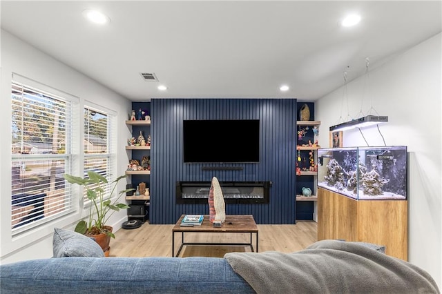 living room featuring a large fireplace and hardwood / wood-style floors