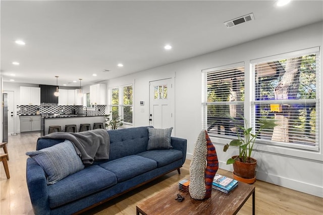 living room with plenty of natural light and light hardwood / wood-style flooring