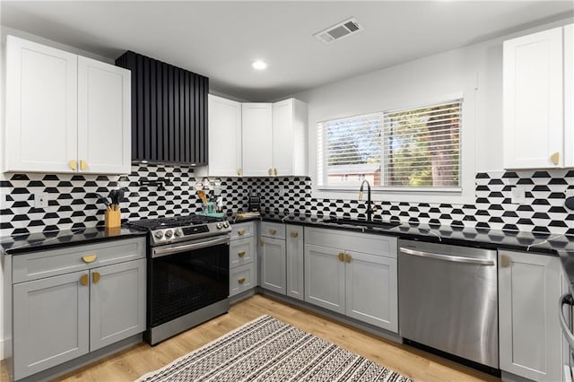 kitchen featuring light hardwood / wood-style flooring, appliances with stainless steel finishes, sink, white cabinets, and gray cabinets