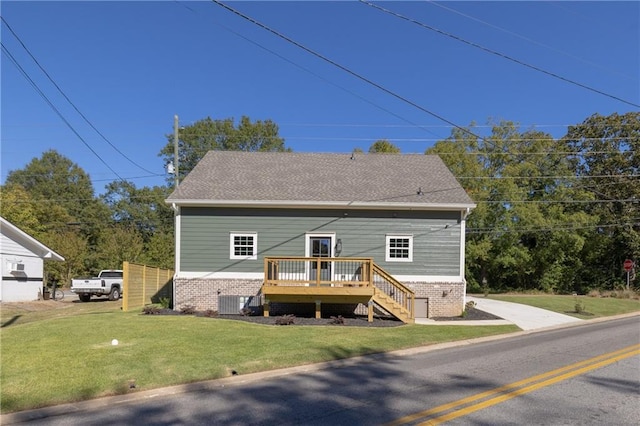 rear view of property featuring a wooden deck and a yard