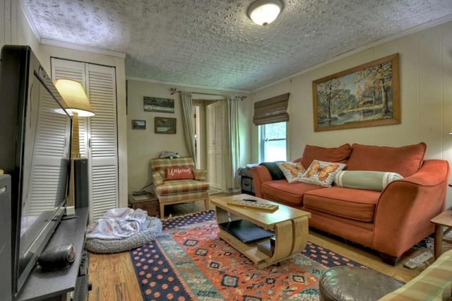 living area featuring wood finished floors, crown molding, and a textured ceiling
