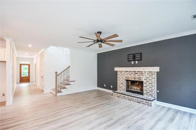 5354 Shadow Walk Way, Gainesville, GA 30507 - unfurnished living room featuring stairs, light wood-style flooring, ornamental molding, a ceiling fan, and a brick fireplace