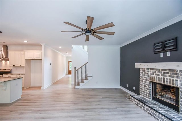 5354 Shadow Walk Way, Gainesville, GA 30507 - unfurnished living room with ornamental molding, light wood-type flooring, ceiling fan, stairway, and baseboards