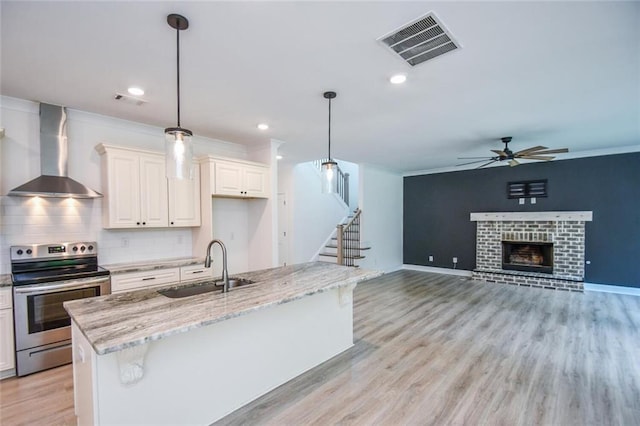 5354 Shadow Walk Way, Gainesville, GA 30507 - kitchen with stainless steel range with electric stovetop, wall chimney exhaust hood, a ceiling fan, a sink, and light stone countertops