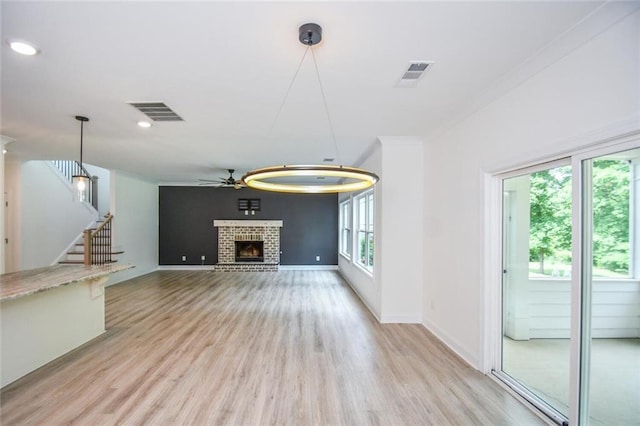 5354 Shadow Walk Way, Gainesville, GA 30507 - unfurnished living room featuring a brick fireplace, light wood finished floors, ceiling fan, stairway, and baseboards