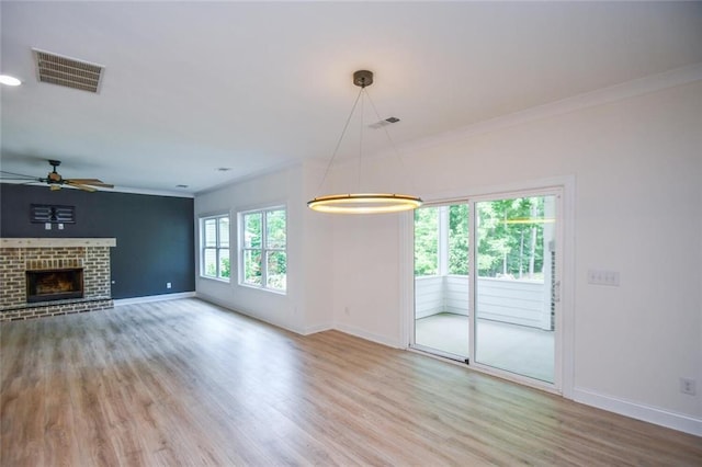 5354 Shadow Walk Way, Gainesville, GA 30507 - unfurnished living room with baseboards, wood finished floors, crown molding, ceiling fan, and a brick fireplace