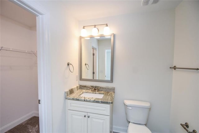 5354 Shadow Walk Way, Gainesville, GA 30507 - bathroom with toilet, vanity, a spacious closet, and baseboards