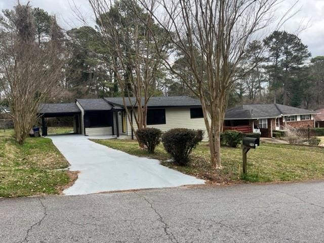 ranch-style house with a carport and a front lawn