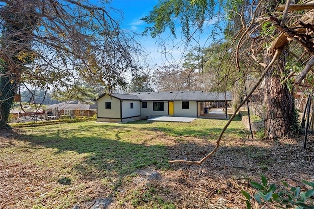 rear view of property with a yard and a patio