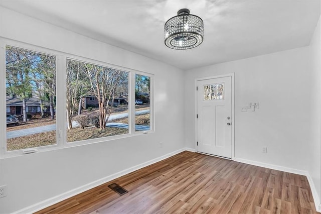 interior space featuring light wood-type flooring and an inviting chandelier