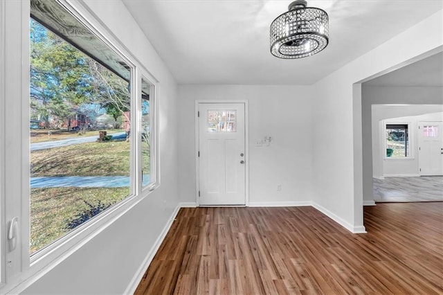 foyer entrance with hardwood / wood-style floors and an inviting chandelier