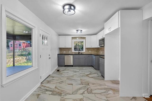 kitchen with decorative backsplash, appliances with stainless steel finishes, gray cabinets, and white cabinetry