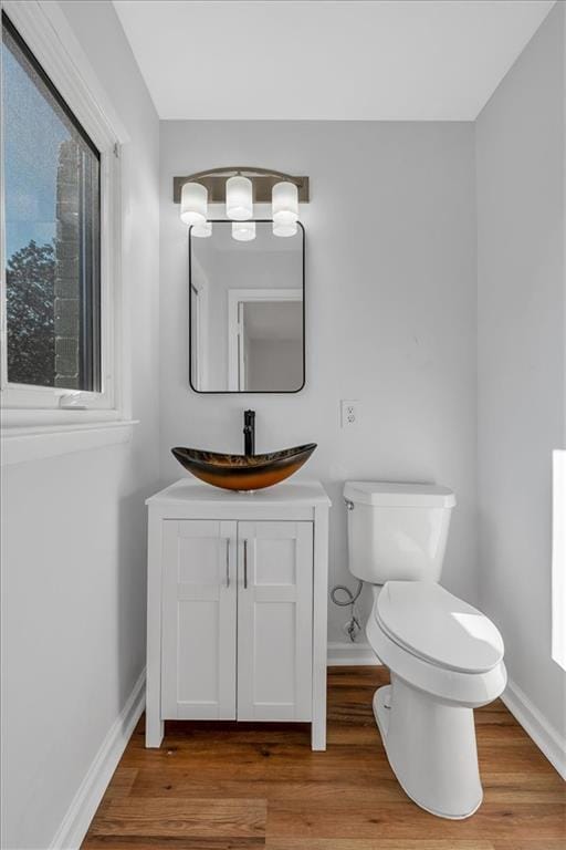 bathroom with hardwood / wood-style floors, vanity, and toilet