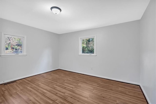 empty room with light wood-type flooring and a healthy amount of sunlight