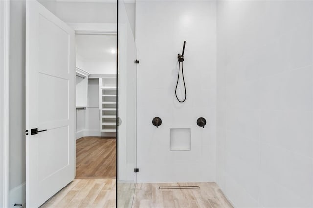 bathroom featuring hardwood / wood-style floors and tiled shower