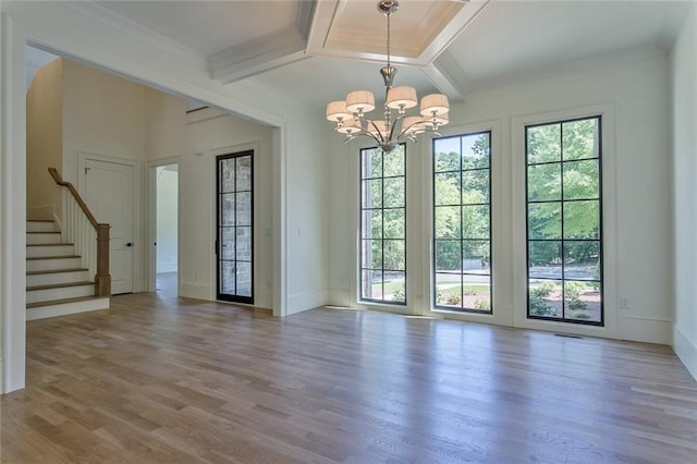 doorway with a notable chandelier, beam ceiling, ornamental molding, and light hardwood / wood-style floors