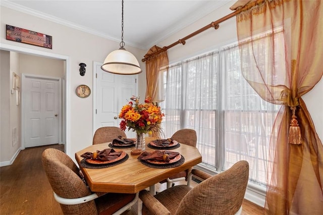 dining room with hardwood / wood-style flooring and crown molding