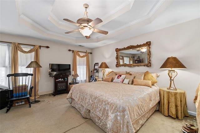 carpeted bedroom featuring a raised ceiling, ceiling fan, and ornamental molding