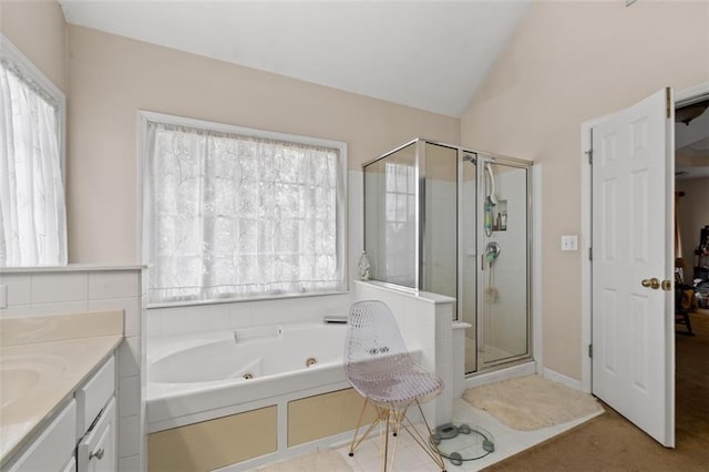 bathroom featuring shower with separate bathtub, vanity, vaulted ceiling, and plenty of natural light